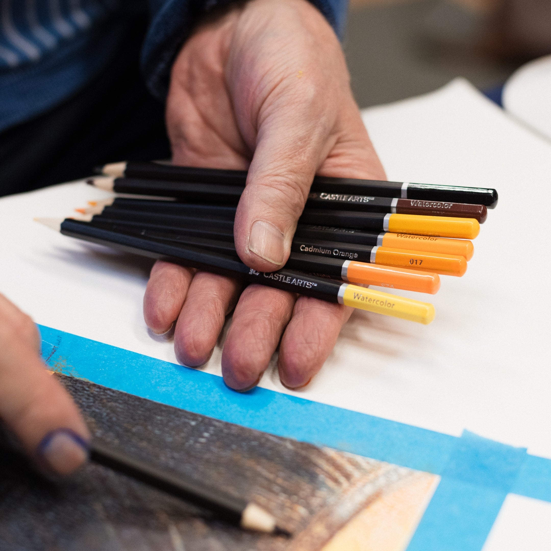 man drawing with castle arts coloured pencils